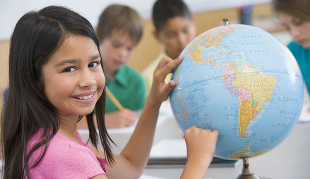 Girl pointing to a globe to illustrate that our School Scheduling Software is used WorldWide